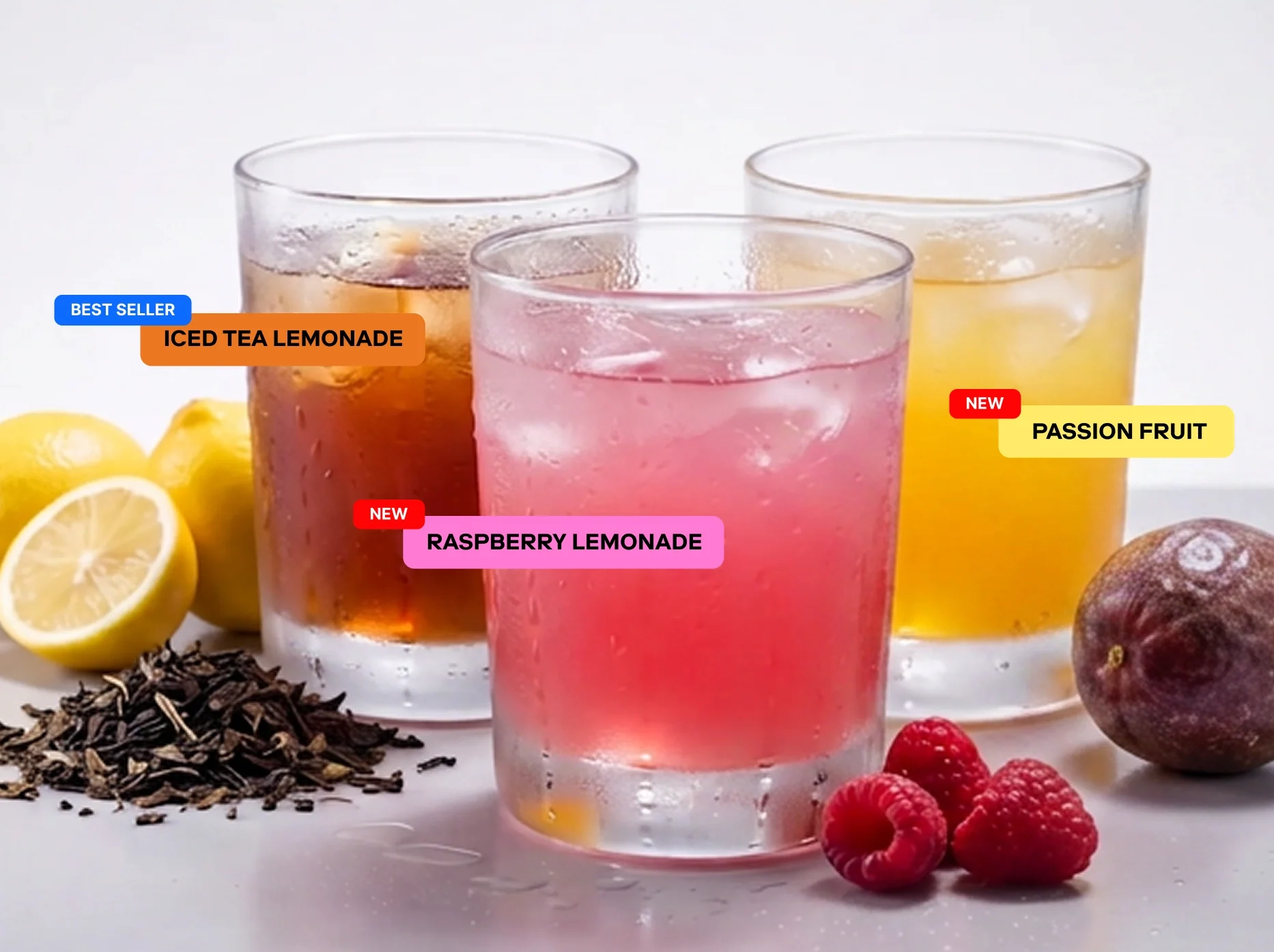 Three glasses: Iced Tea Lemonade, Raspberry Lemonade and Passion Fruit, with lemon, tea leaves, raspberries and passion fruit