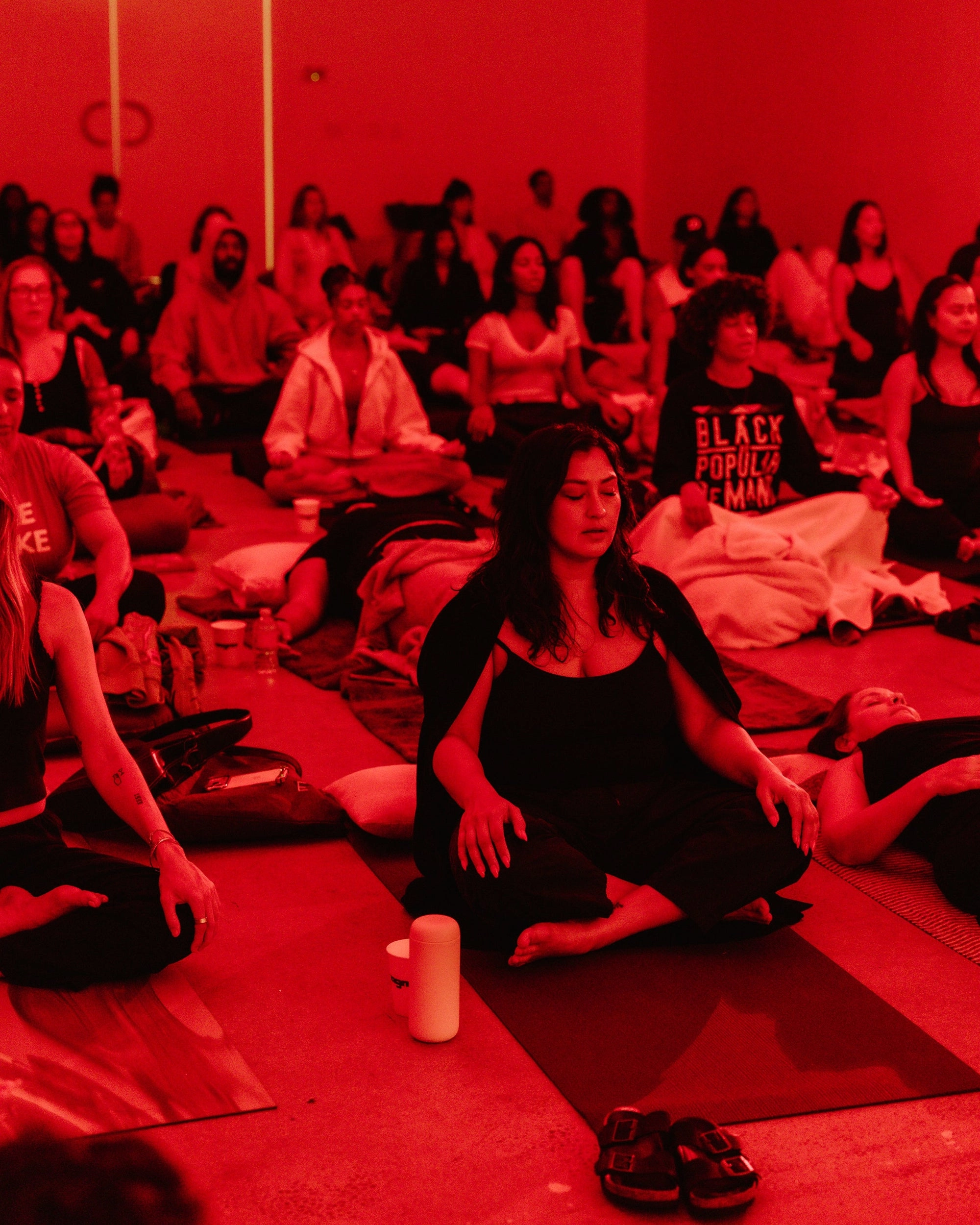 A seated group class in a room lit red