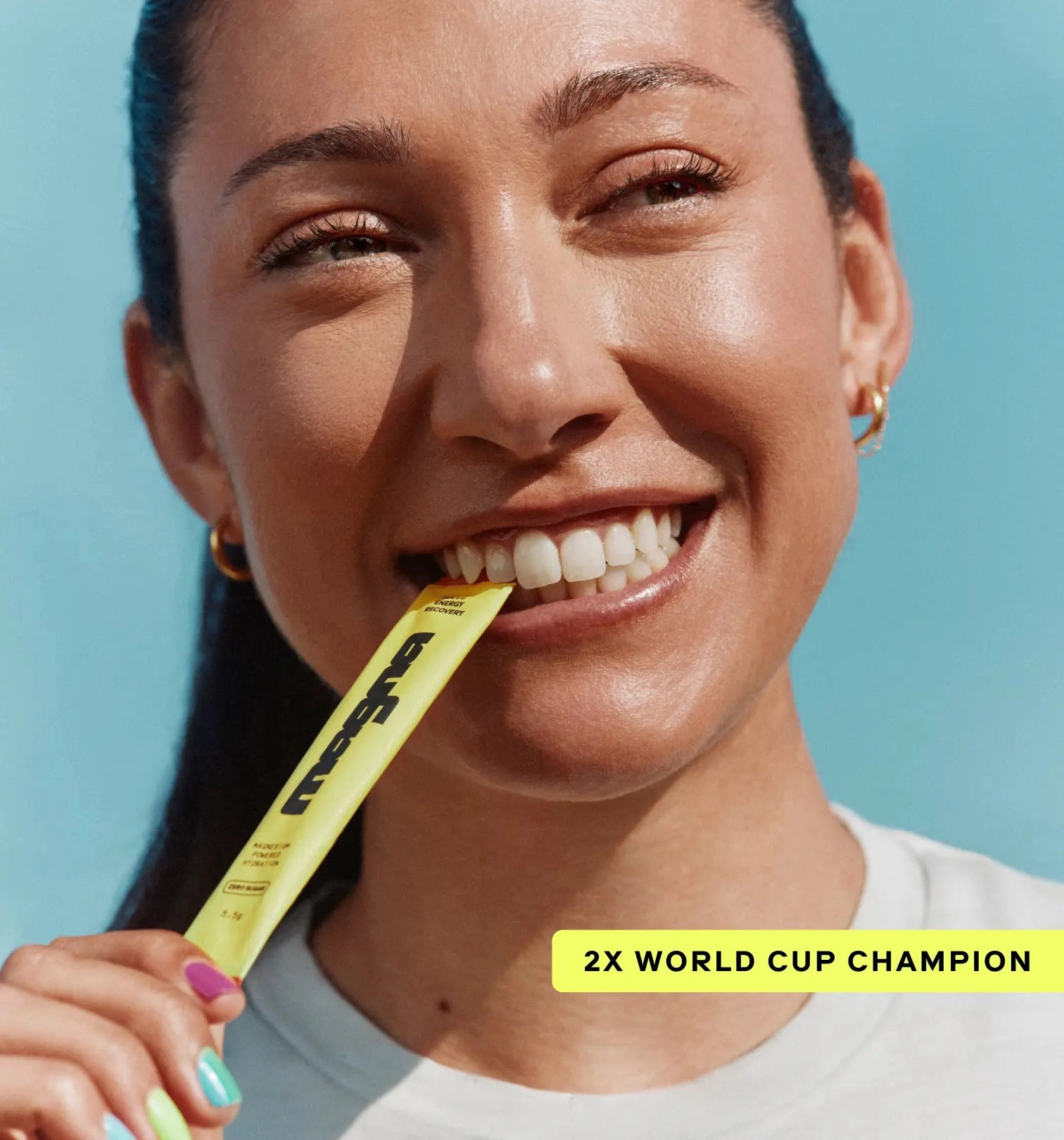 Woman smiling, biting a yellow packet, with '2X World Cup Champion' text.